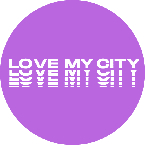 A circular graphic with a purple background featuring the phrase "LOVE MY CITY" in white text. The text appears with varying thickness and spacing, creating a distinctive visual effect.