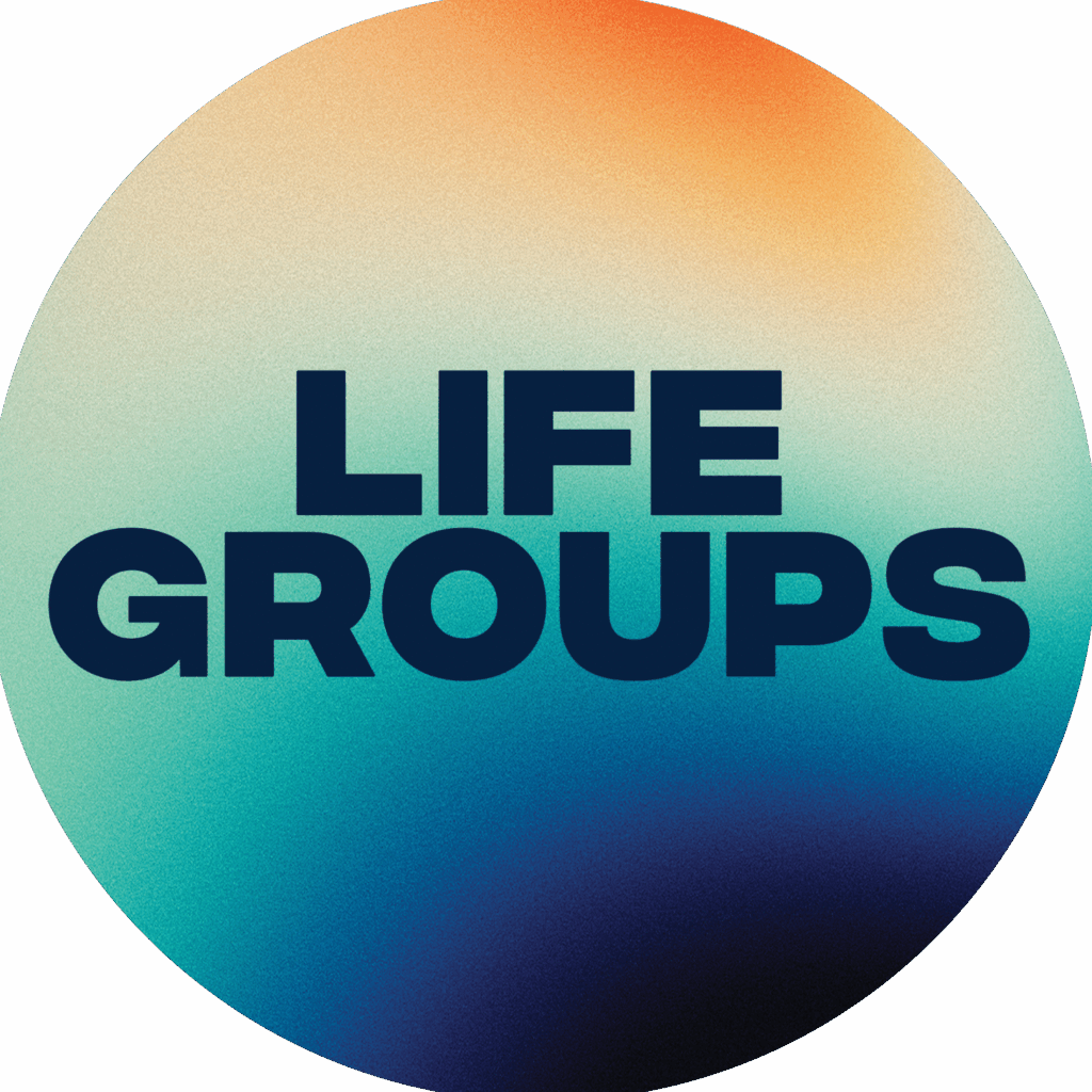 A circular graphic featuring a gradient background that transitions from orange at the top to blue at the bottom. Bold text in dark blue reads 'LIFE GROUPS' and is centered within the circle.